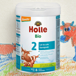 Holle Bio baby formula container with cow illustration on a colorful background